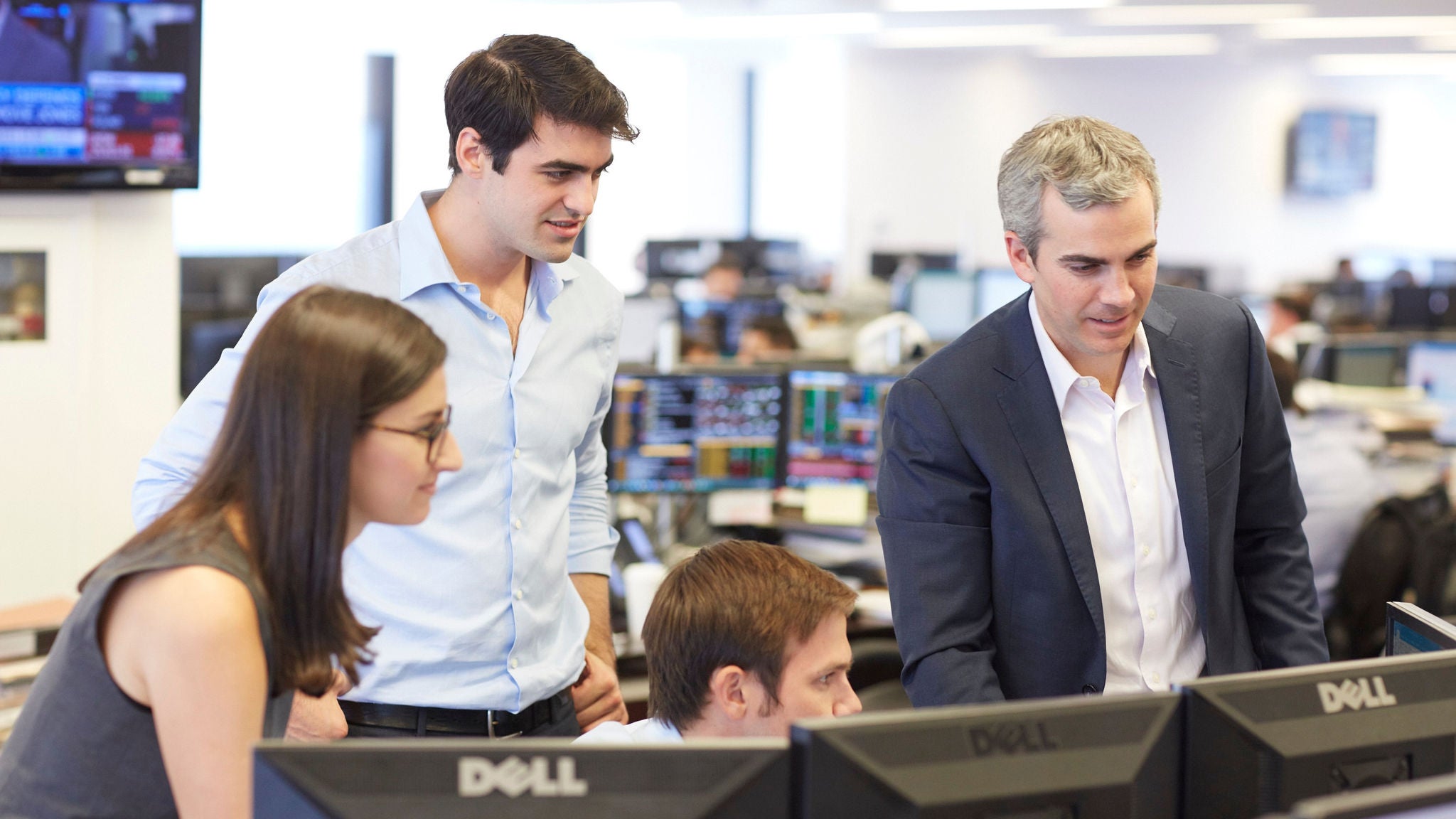 colleagues gathered around a computer in the Apollo office