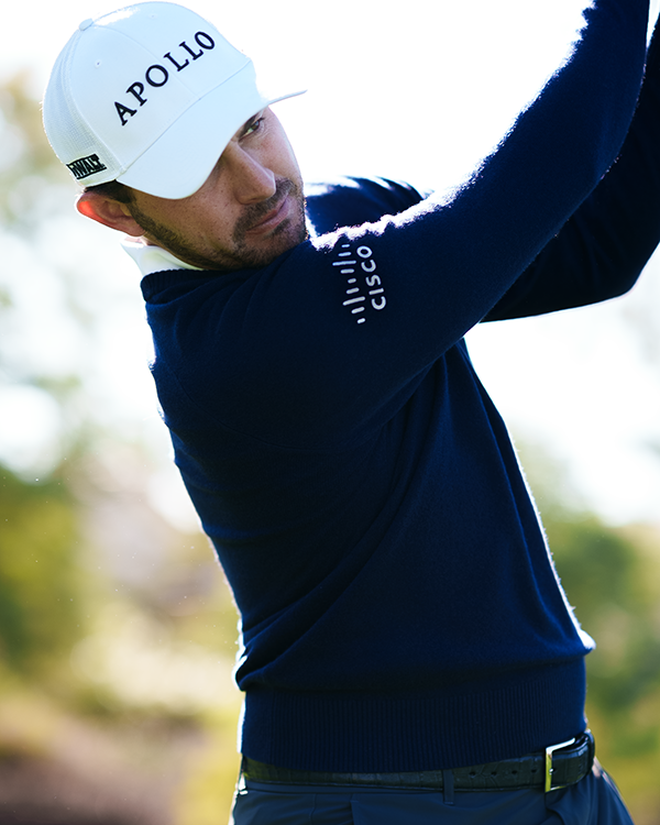 action shot of golfer Patrick Cantlay wearing a hat with the Apollo logo