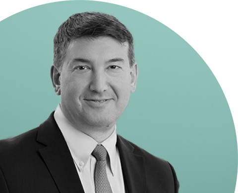 Black-and-white portrait of Scott Kleinman in a suit and tie against a soft green background. Executive headshot accompanying commentary in Apollo’s sustainability reporting materials and annual sustainability report content.