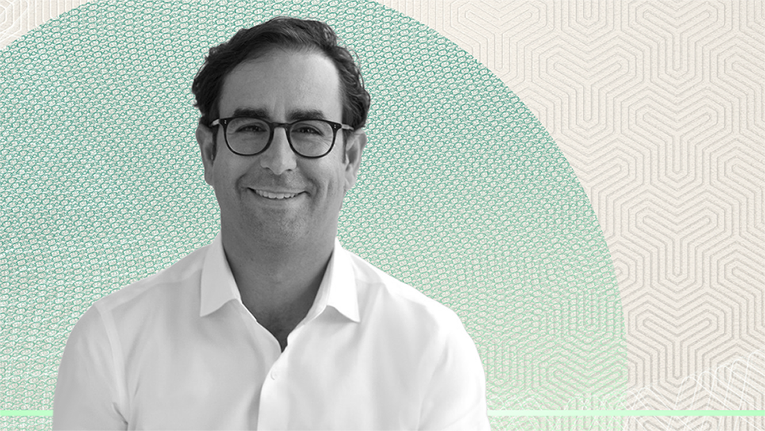 Black-and-white portrait of Apollo's John Zito wearing glasses and a white shirt, smiling against a textured green circular background, used in an interview discussing software, AI disruption, and asset management perspectives.