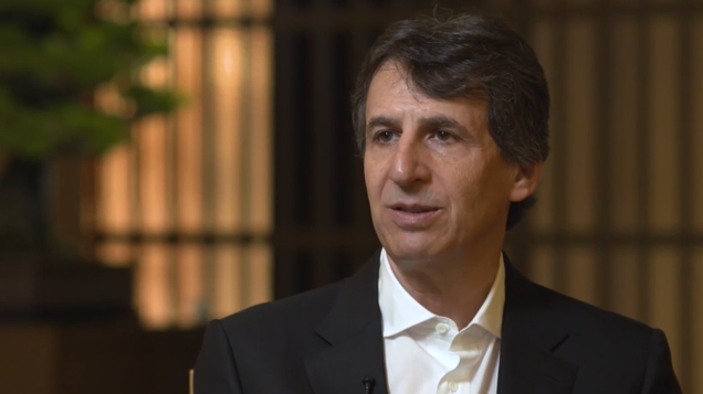 Apollo CEO Marc Rowan sits in a warmly lit interview setting in Tokyo, wearing a dark suit and white shirt, as he discusses Japan’s economic reset, inflation, retirement income demand, governance reform and evolving capital markets conditions.