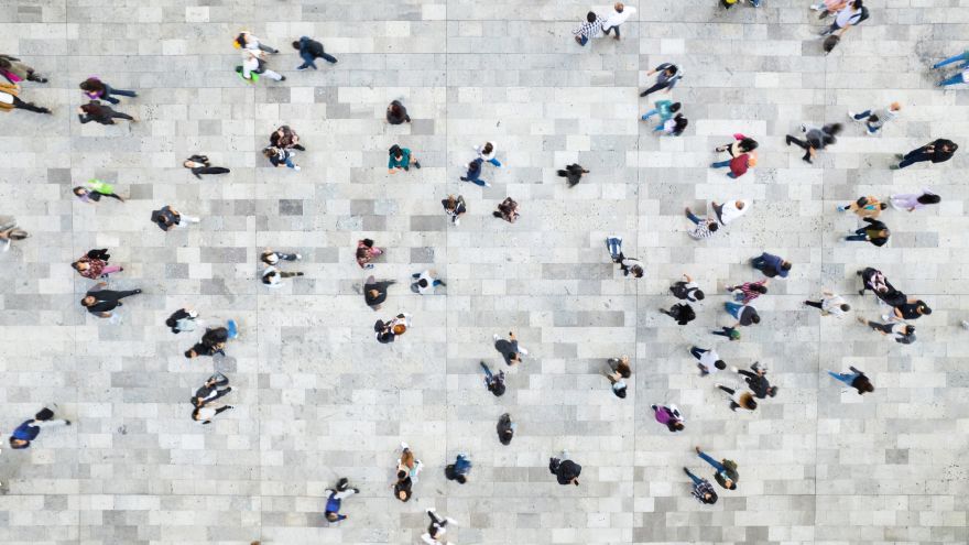 Overhead view of pedestrians moving in different directions across a broad stone plaza, reflecting the varied paths and allocation considerations that can shape wealth and fixed income portfolios.