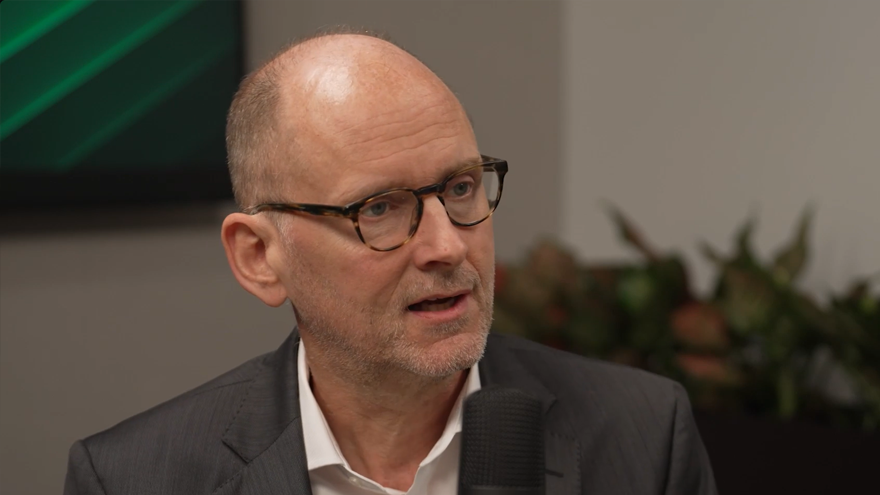Torsten Slok, Apollo Partner and Chief Economist, sits in an office and speaks into a microphone during a podcast discussion about the key economic and market forces shaping the 2026 mid-year outlook.  