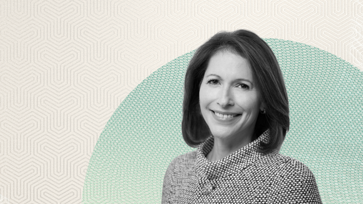 Black-and-white portrait of Stephanie Drescher in a patterned jacket, smiling in front of a beige and mint green background, discussing alternative investments.